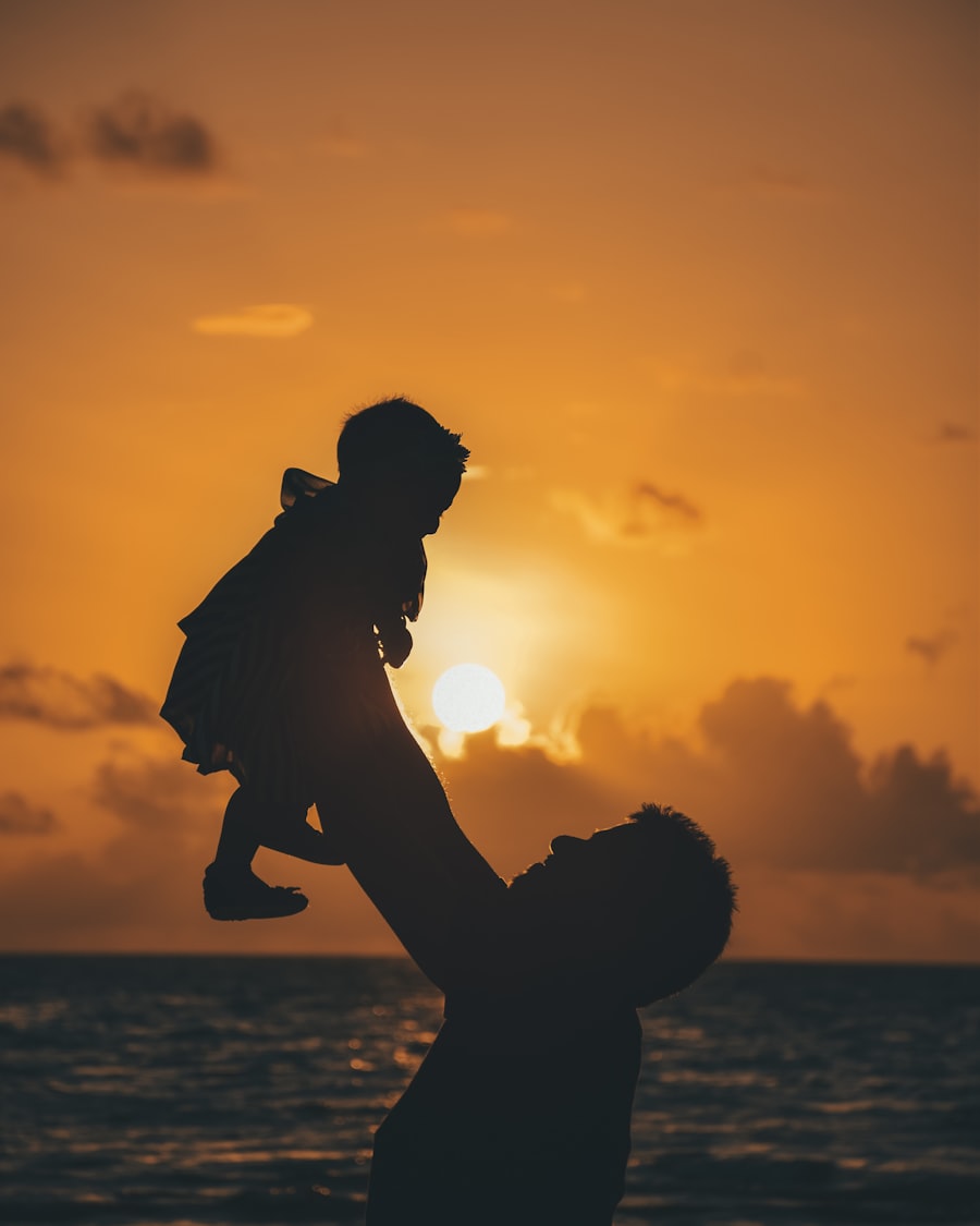 Papá levantando en brazos a su hijo durante el atardecer